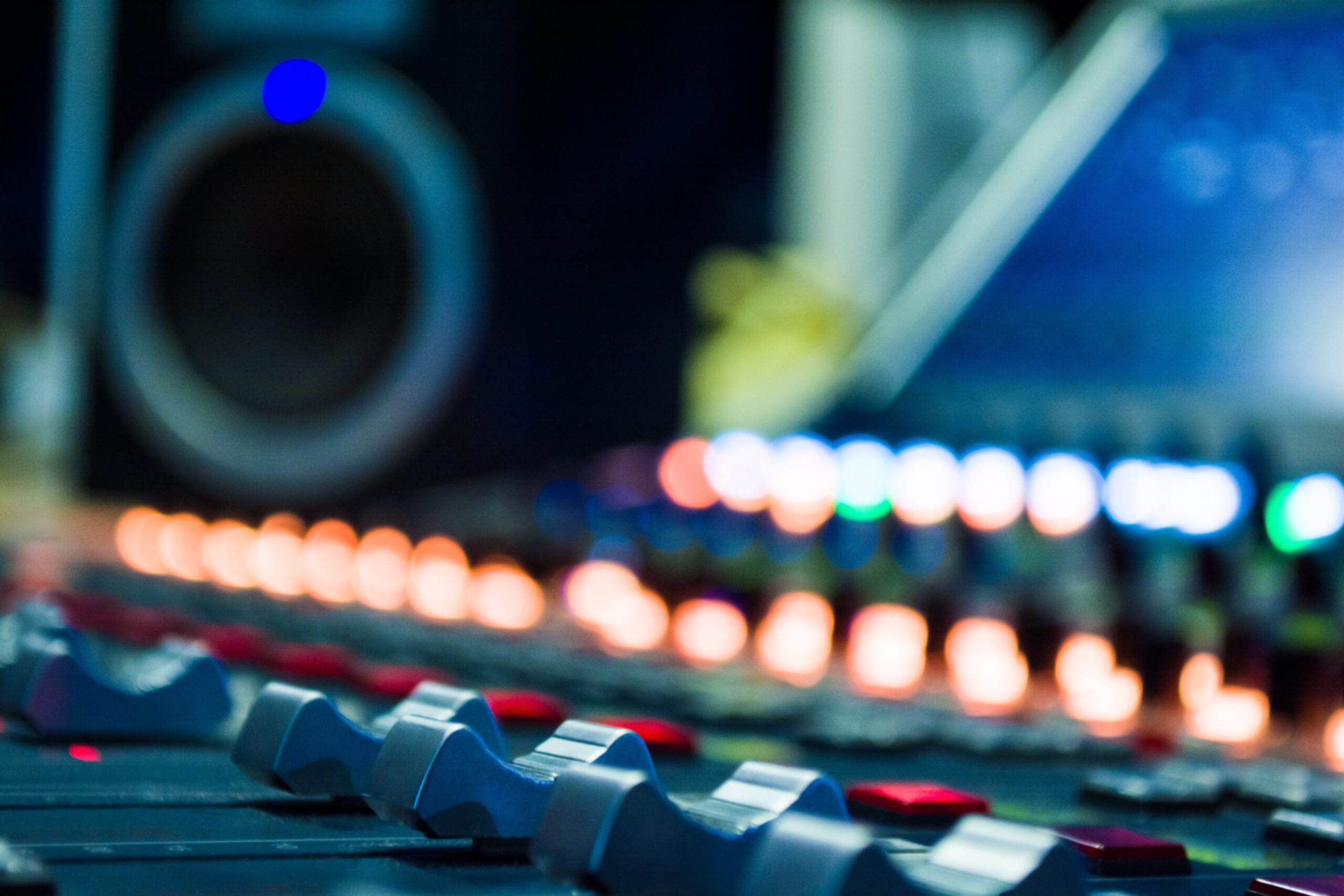 detail of a music mixer in studio with editing tools on blur speaker
